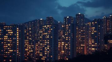 A bustling urban skyline at twilight with illuminated high-rise buildings and a backdrop of distant mountains photo