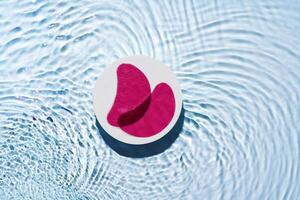 Eye patches floating on clear water with gentle ripples photo