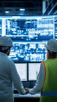 Engineers monitor data analysis on multiple screens in a high-tech control room during evening hours photo