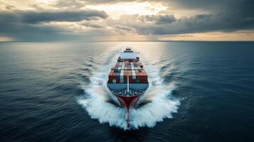Container ship navigating through calm waters at dusk with clouds overhead and warm light reflecting on the ocean surface photo