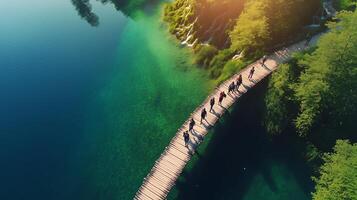 People walking on a wooden bridge in a serene lake environment during sunset in a picturesque natural setting photo