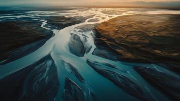 Aerial view of winding rivers flowing through a vast landscape at sunset, highlighting the intricate patterns of nature in this serene location photo