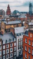 Aerial view of Manchester's historic architecture blending with modern skyscrapers under a cloudy sky photo