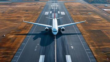 Airplane preparing for takeoff on a clear runway during daylight at a busy international airport photo