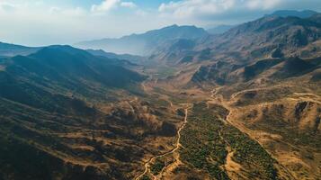 Aerial view of a vast mountainous landscape with winding valleys and green patches during daylight hours photo