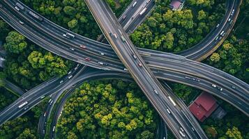 Aerial view of a complex highway interchange surrounded by lush green trees in a vibrant urban area during daylight photo