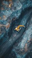 Aerial view of an excavator working in a rocky terrain during daylight in a quarry site photo