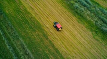 Aerial view of a red tractor working in a lush green field during the day, demonstrating modern agricultural practices photo