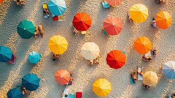 Colorful beach umbrellas in a sunny coastal location with people enjoying leisure time during the summer season photo