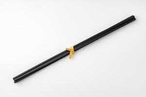 Black aromatic sticks resting on a plain white background photo