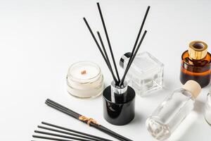 Aromatic essentials including scented candles, incense sticks, and diffusers arranged on a light background photo