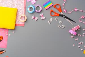 Crafting supplies arranged for a DIY project on a gray table with scissors, washi tape, and decorative items photo