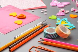 Crafting materials and tools arranged on a gray surface during a creative project photo