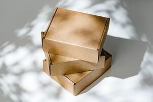 Freshly packed cardboard boxes resting on a white surface, illuminated by soft natural light photo