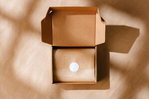 A sealed kraft box containing a wrapped item, positioned on a textured brown surface for an unboxing experience photo