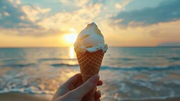 Enjoying a creamy ice cream cone by the seaside at sunset with golden hues illuminating the tranquil waves photo