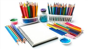 Art supplies arranged on a table with colored pencils, sketchbook, and paints ready for a creative project at home photo