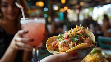 Enjoying vibrant tacos with fresh toppings and a colorful drink in a lively restaurant setting during a sunny afternoon photo