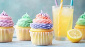 Colorful cupcakes with swirl frosting and refreshing lemonade on a light background photo