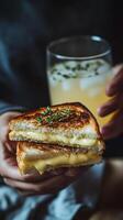 Cheesy grilled sandwich served alongside a refreshing beverage in a cozy indoor setting during the evening photo