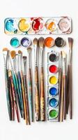 A vibrant collection of paintbrushes and watercolors arranged neatly on a white surface, showcasing artistic tools for creative expression photo