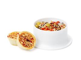 Nutritious seed mix served in a bowl with additional snacks for pet at home photo