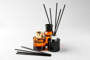 Elegant arrangement of essential oil diffusers with reeds and glass bottles on a minimalist surface photo