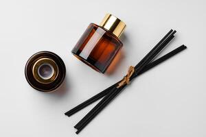 A minimalist display of essential oil and black diffuser sticks on a clean white background photo