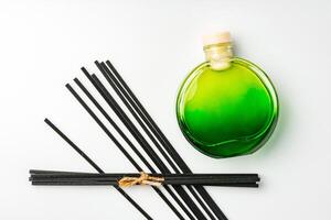 A minimalist display of essential oil and black diffuser sticks on a clean white background photo