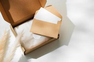 Delivery package with a blank envelope and decorative elements on a light background photo