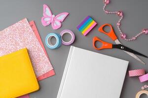 Crafting supplies arranged for a DIY project on a gray table with scissors, washi tape, and decorative items photo