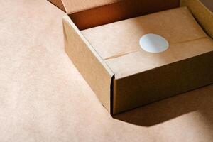 A sealed kraft box containing a wrapped item, positioned on a textured brown surface for an unboxing experience photo
