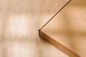 A plain cardboard box on a textured surface with soft light and shadows during the afternoon photo