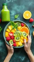 Fresh fruit salad with kiwi, mango, raspberries, and oranges captured in a kitchen on a vibrant green backdrop photo