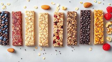 Colorful assortment of energy bars arranged on a light background with nuts and fruits, showcasing healthy snack options for any time of day photo