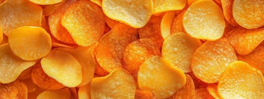 Golden potato chips scattered on a surface, showcasing their crispy texture and vibrant color, perfect for snacking anytime photo
