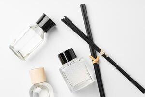 Elegant arrangement of essential oil diffusers with reeds and glass bottles on a minimalist surface photo