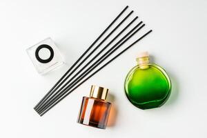 A minimalist display of essential oil and black diffuser sticks on a clean white background photo