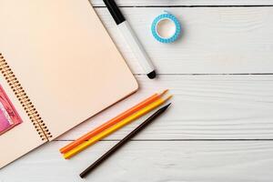 Creative workspace with open notebook, stationery, and decorative items on a wooden table photo