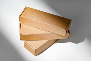 Freshly packed cardboard boxes resting on a white surface, illuminated by soft natural light photo
