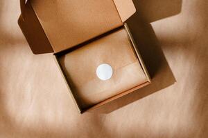 A sealed kraft box containing a wrapped item, positioned on a textured brown surface for an unboxing experience photo