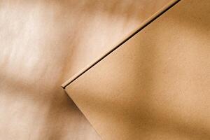 A plain cardboard box on a textured surface with soft light and shadows during the afternoon photo
