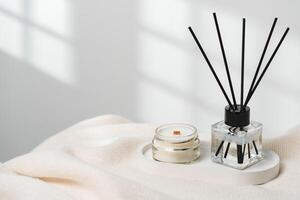 Elegant Aroma Diffuser With Reed Sticks And Scented Candle On White Tablecloth photo