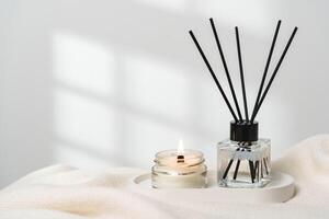 Elegant Aroma Diffuser With Reed Sticks And Scented Candle On White Tablecloth photo