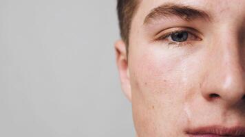 Eyewinker. Close up shot of crying guy face, man rubbing sore eye, slow motion, empty space video
