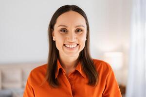 Beautiful smiling woman looking at camera while posing at home photo