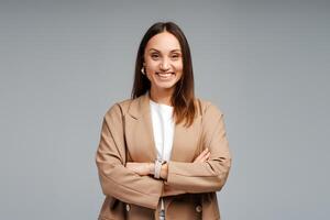 Portrait of smiling young businesswoman with arms crossed, posing in studio, looking at camera photo