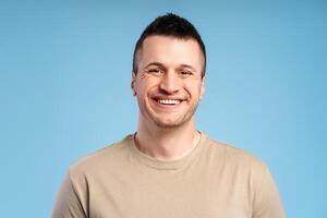 Portrait of smiling happy man, close-up, isolated on blue background, looking at camera photo