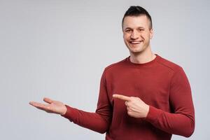 Smiling man pointing finger to empty space hand isolated on gray banner background photo