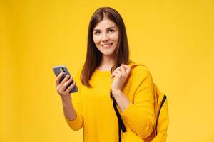 Attractive smiling middle aged woman holding backpack, mobile phone, using mobile app text message photo